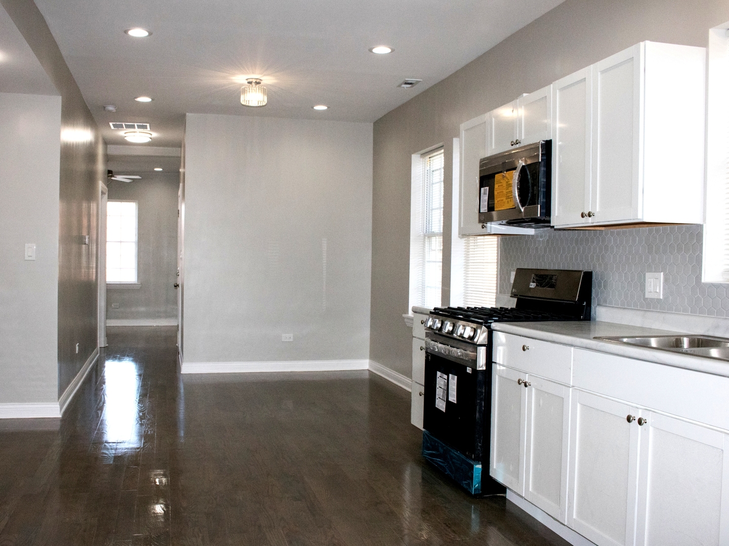3257 West Warren Boulevard, Unit 2 Chicago, IL 60624 - Photo 4 of 10 a kitchen with a sink stainless steel appliances and white cabinets