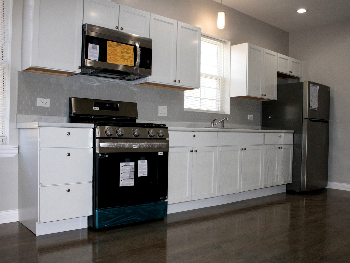 3257 West Warren Boulevard, Unit 2 Chicago, IL 60624 - Photo 5 of 10 a kitchen with stainless steel appliances granite countertop a stove a sink and a microwave