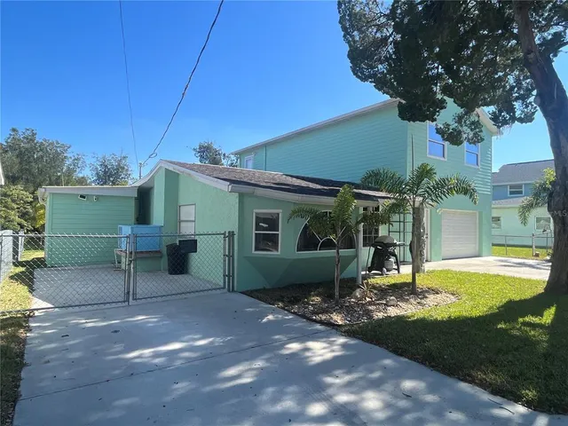 a view of a chair and table in backyard of the house
