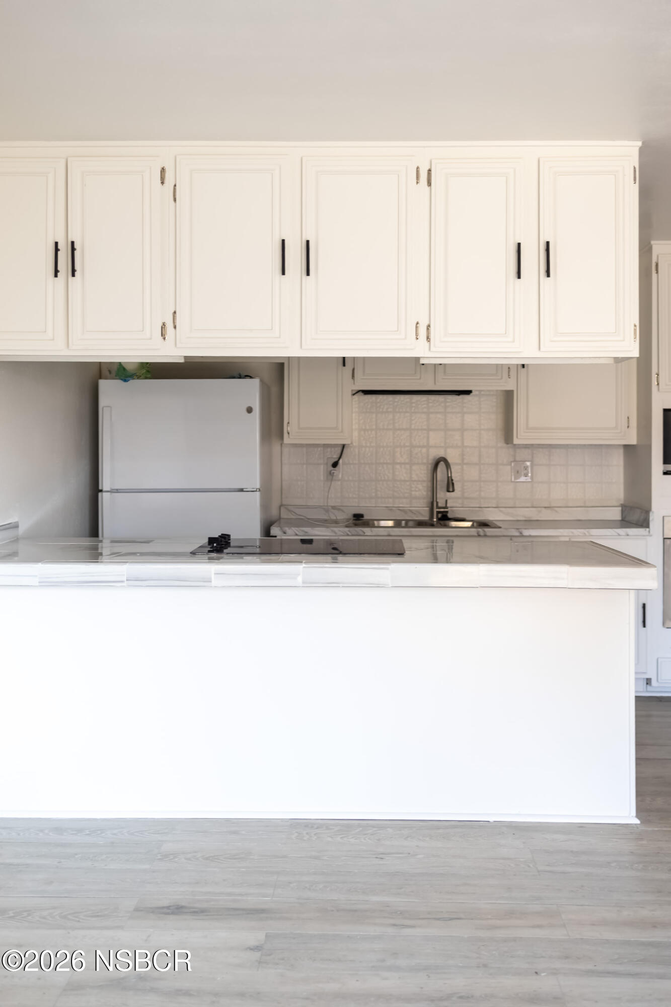 829 Jones Street, Unit 4 Santa Maria, CA 93454 - Photo 3 of 15 a close view of kitchen countertops with cabinets and wooden floor