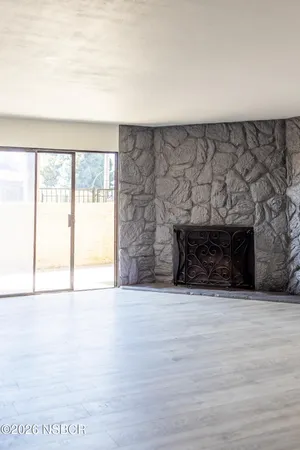 a view of an empty room with a fireplace and a window