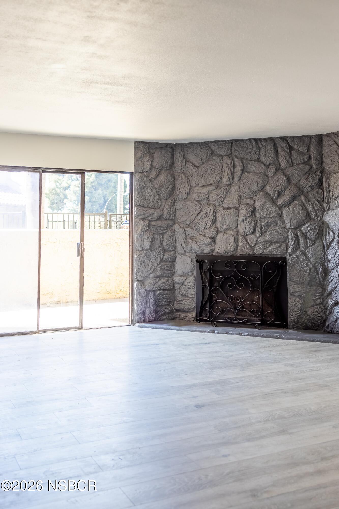 829 Jones Street, Unit 4 Santa Maria, CA 93454 - Photo 4 of 15 a view of an empty room with a fireplace and a window