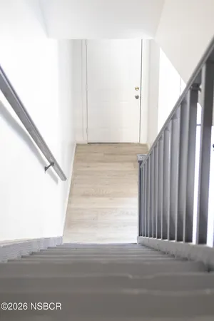 a view of staircase with white walls and railing