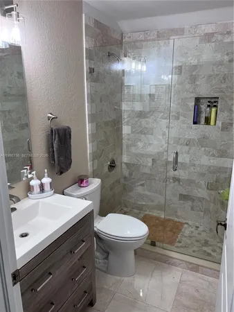 a bathroom with a sink a toilet and shower
