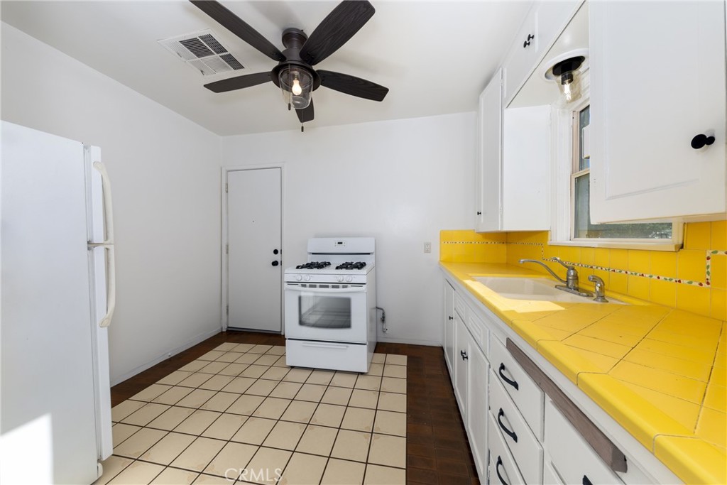 1208 Ohio Street Redlands, CA 92374 - Photo 4 of 14 a kitchen with a sink a stove cabinets and stainless steel appliances