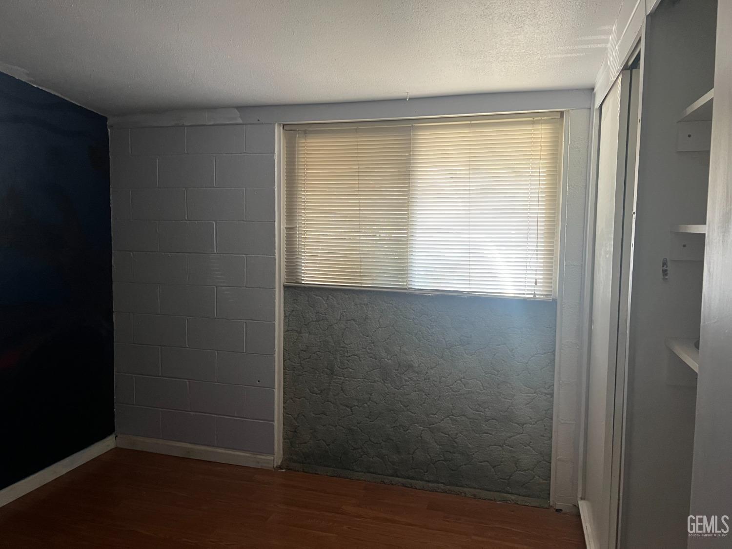 Undisclosed Address Delano, CA 93215 - Photo 9 of 17 a view of an empty room with wooden floor and a window