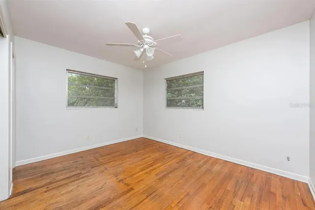 a view of empty room with wooden floor