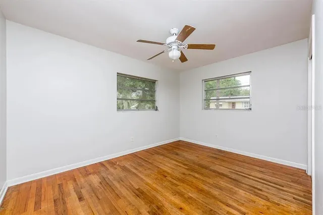 a view of empty room with wooden floor