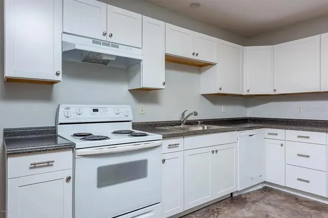 a kitchen with white cabinets and appliances