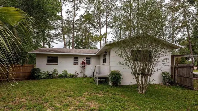 a living room with furniture a flat screen tv and kitchen view