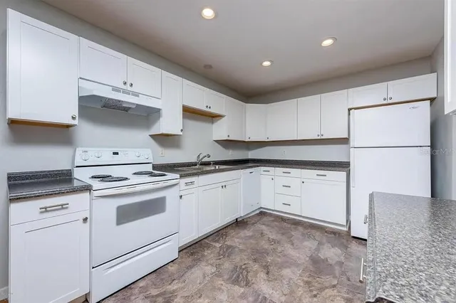 a kitchen with cabinets appliances and a sink