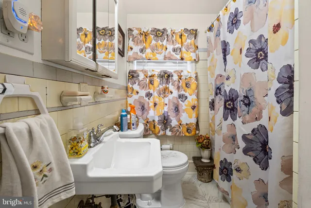 a bathroom with a sink toilet and shower curtain