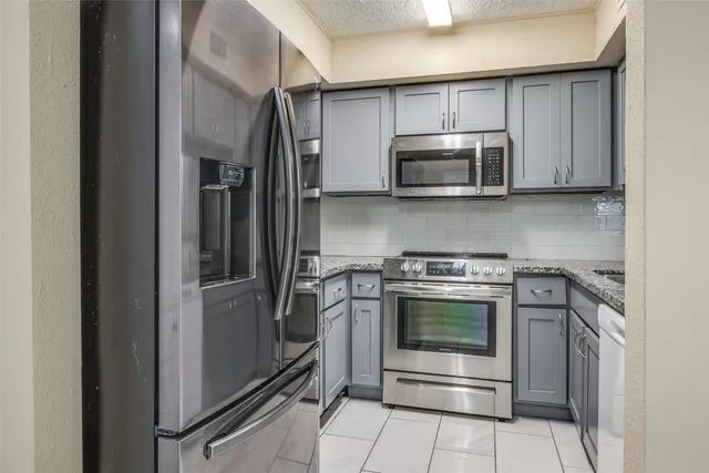 a kitchen with stainless steel appliances granite countertop a stove microwave and sink