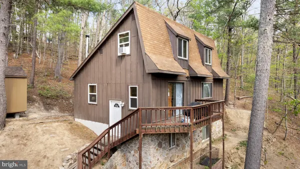 a view of a house with large windows and wooden deck