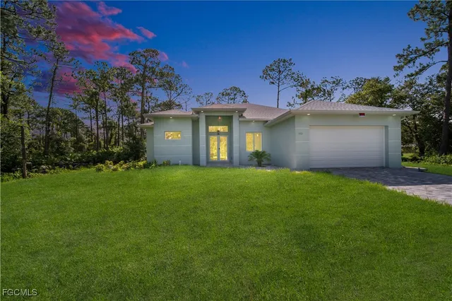 a front view of a house with a garden and yard