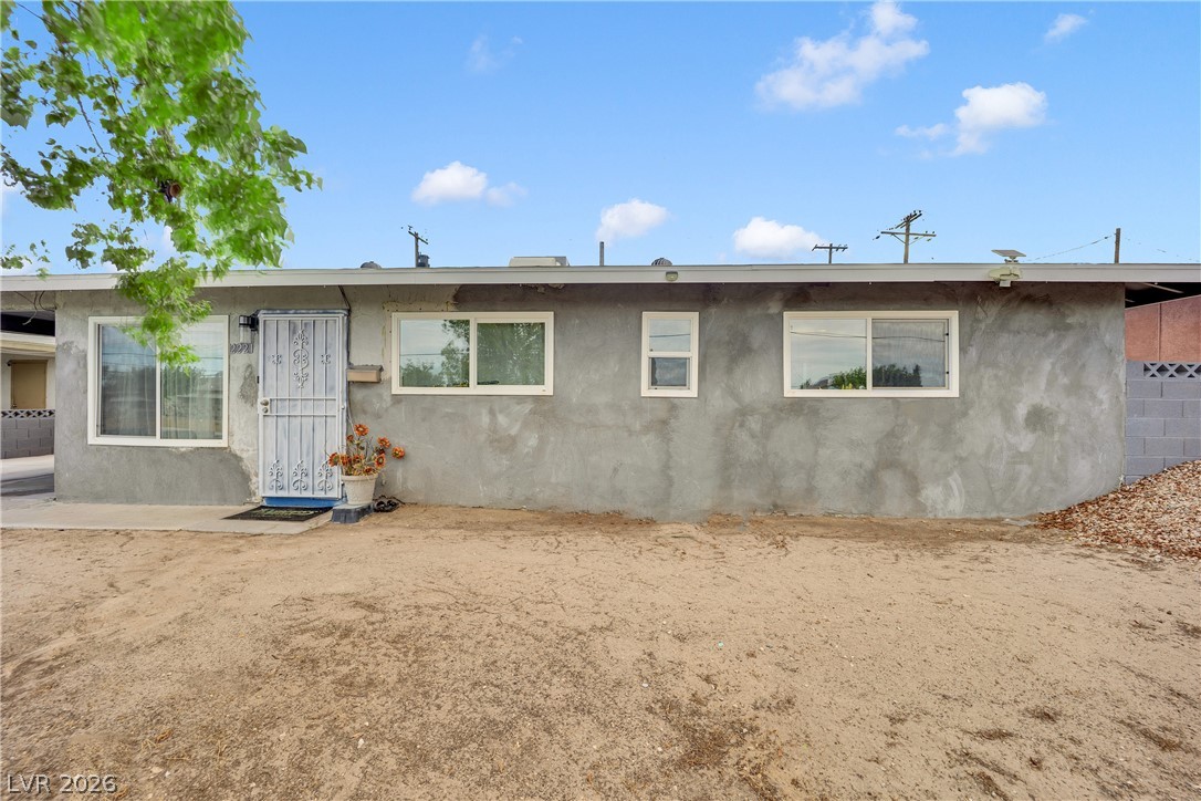 2221 Englestad Street North Las Vegas, NV 89030 - Photo 3 of 32 A modest stucco exterior with multiple windows, offering potential for creative landscape design.