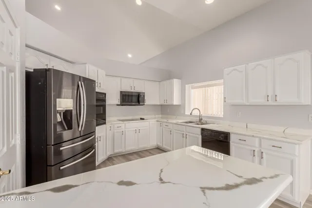 a kitchen with stainless steel appliances granite countertop a refrigerator sink stove microwave and cabinets