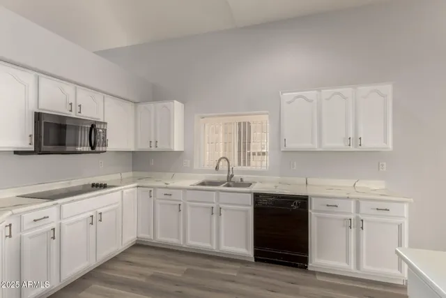 a kitchen with white cabinets stainless steel appliances and sink