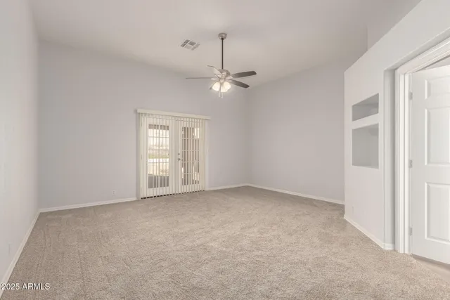an empty room with chandelier fan