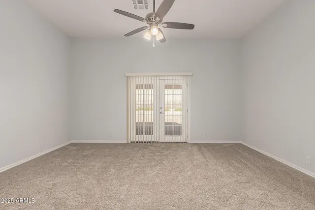 an empty room with a window and a fan