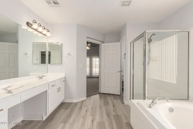 a bathroom with a double vanity sink a mirror and a bathtub