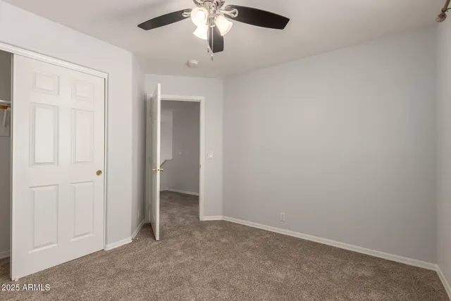 an empty room with chandelier fan