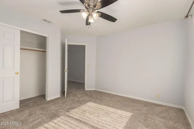 a view of an empty room with a ceiling fan