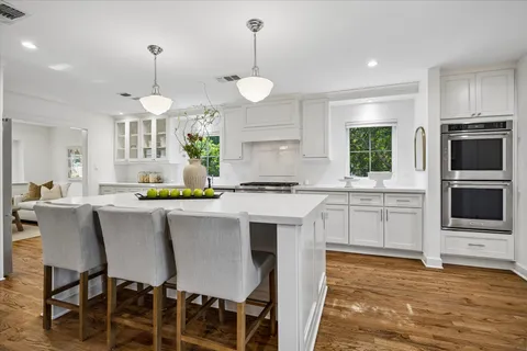 a kitchen with a table chairs microwave and cabinets