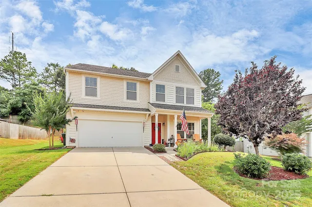 a front view of a house with a yard and trees