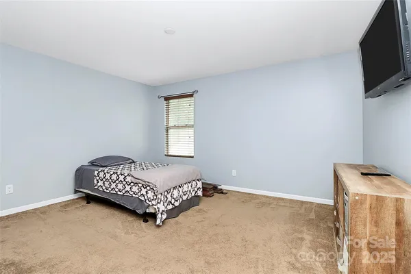 a bedroom with a bed and a television