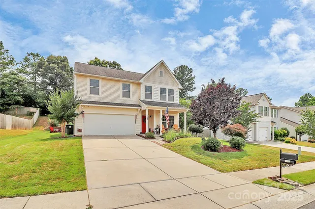 a front view of house with yard and trees around