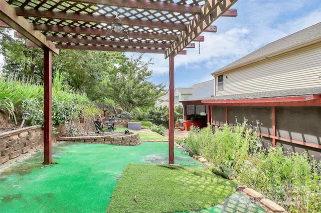 a backyard of a house with wooden floor and fence in the back