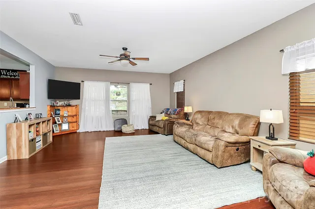 a living room with furniture flat screen tv and wooden floor