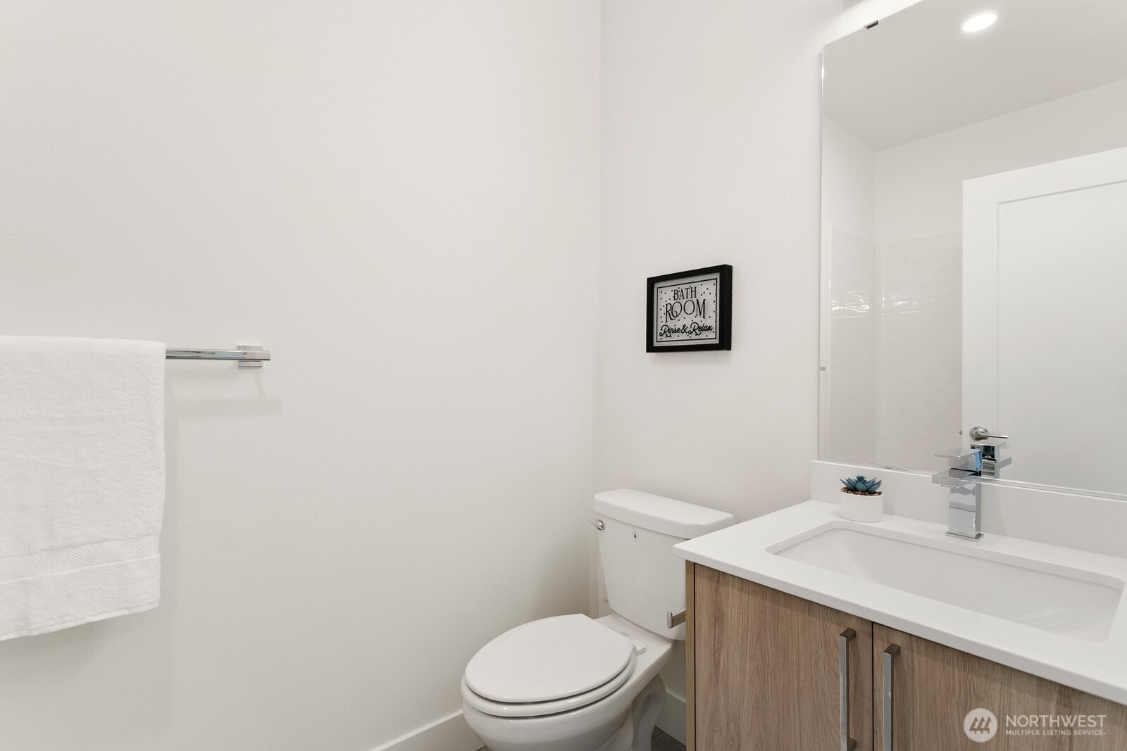 117 Wells Avenue South, Unit D Renton, WA 98057 - Photo 20 of 26 a bathroom with a sink a toilet and a mirror