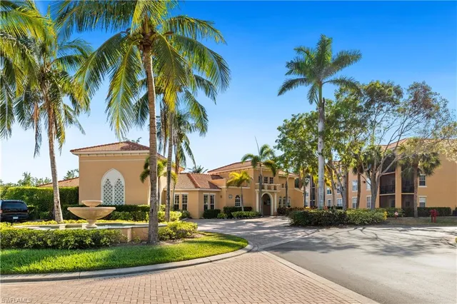 a view of a white house with a yard and palm trees