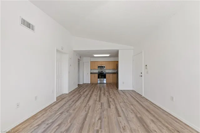 a view of a room with wooden floor and a ceiling fan