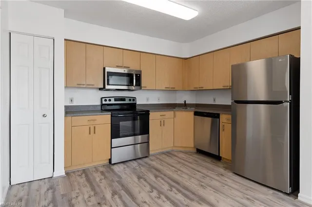 a kitchen with a refrigerator sink and stove top oven