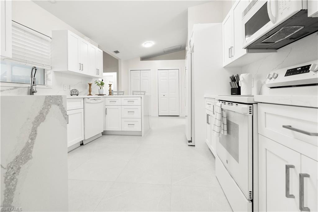 1410 San Marco Road Marco Island, FL 34145 - Photo 14 of 50 a kitchen with white cabinets and white appliances