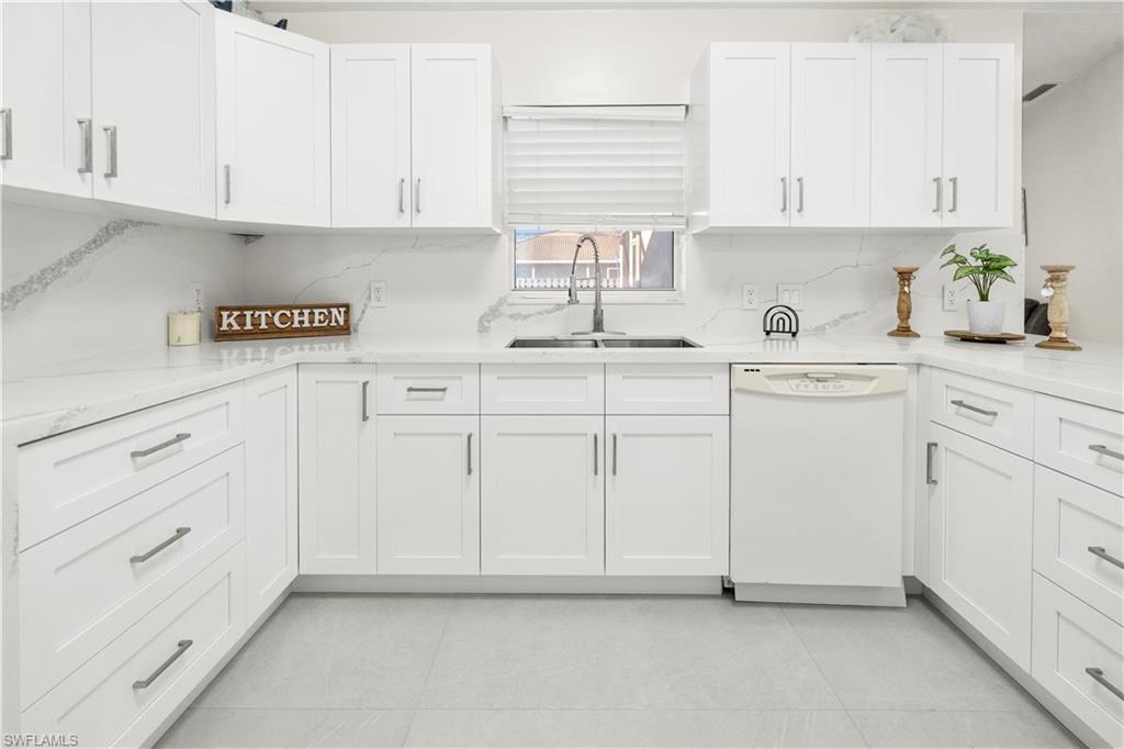 1410 San Marco Road Marco Island, FL 34145 - Photo 15 of 50 a kitchen with white cabinets and white appliances