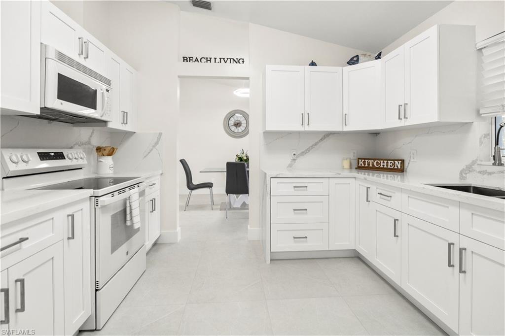 1410 San Marco Road Marco Island, FL 34145 - Photo 16 of 50 a kitchen with white cabinets and white appliances