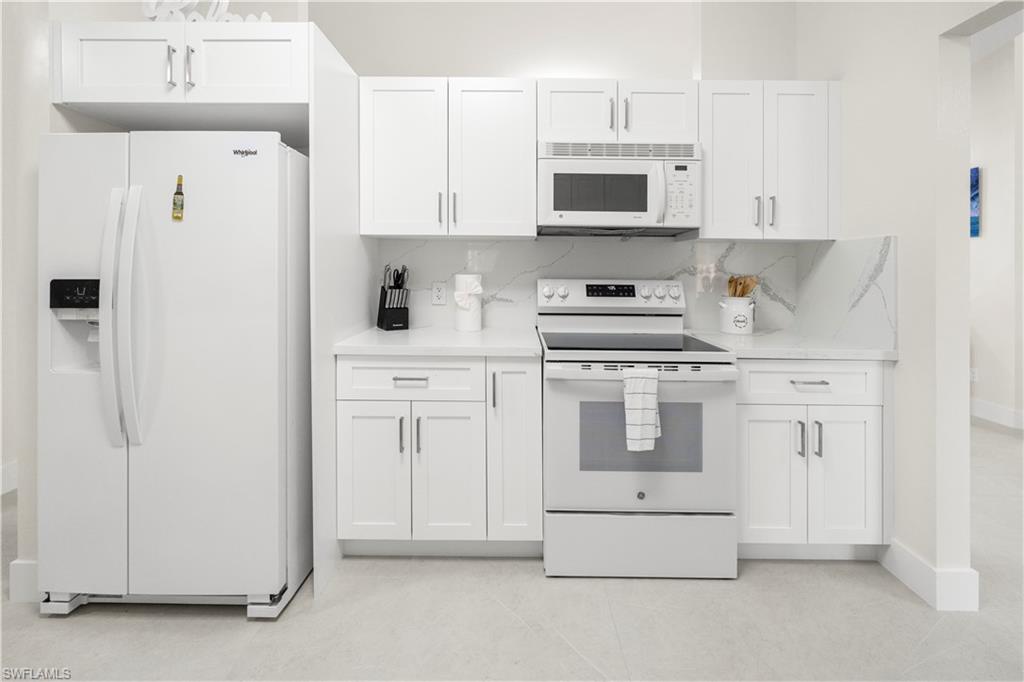 1410 San Marco Road Marco Island, FL 34145 - Photo 19 of 50 a kitchen with white cabinets and white appliances