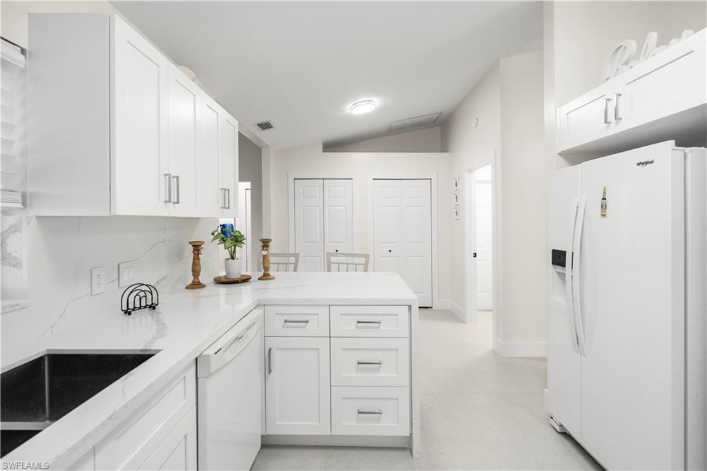 1410 San Marco Road Marco Island, FL 34145 - Photo 20 of 50 a kitchen with white cabinets and refrigerator