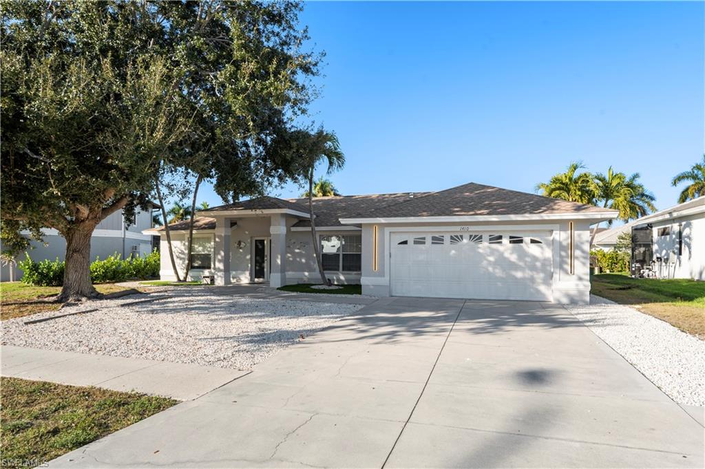 1410 San Marco Road Marco Island, FL 34145 - Photo 2 of 50 a view of a house with a yard and a garage
