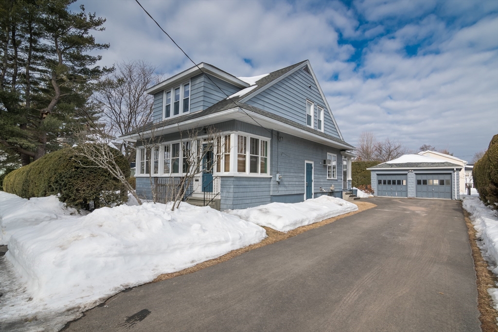 a front view of house with yard covered in snow