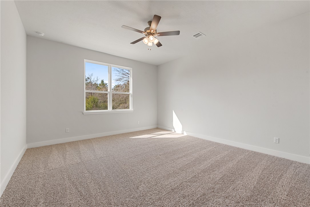 8452 Muir Wood Loop Anderson, TX 77830 - Photo 21 of 48 an empty room with a window and a ceiling fan
