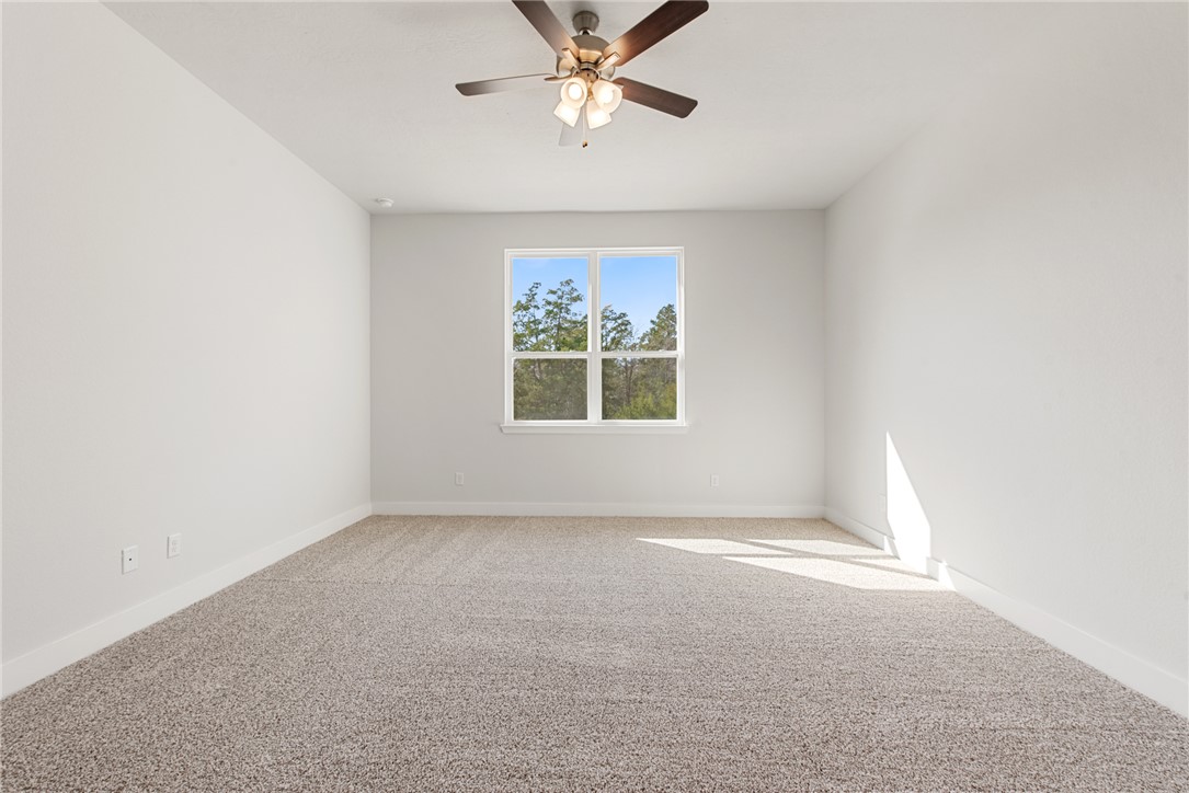 8452 Muir Wood Loop Anderson, TX 77830 - Photo 23 of 48 an empty room with windows and fan