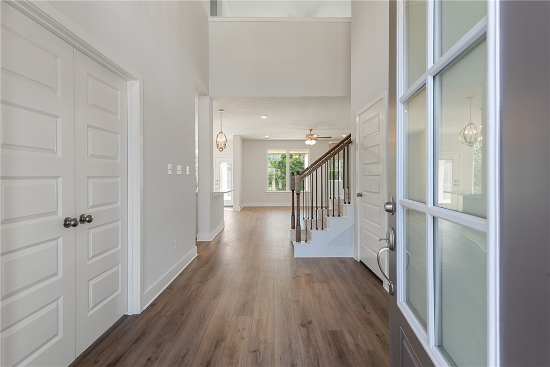 8452 Muir Wood Loop Anderson, TX 77830 - Photo 3 of 48 a hallway with wooden floor windows and stairs