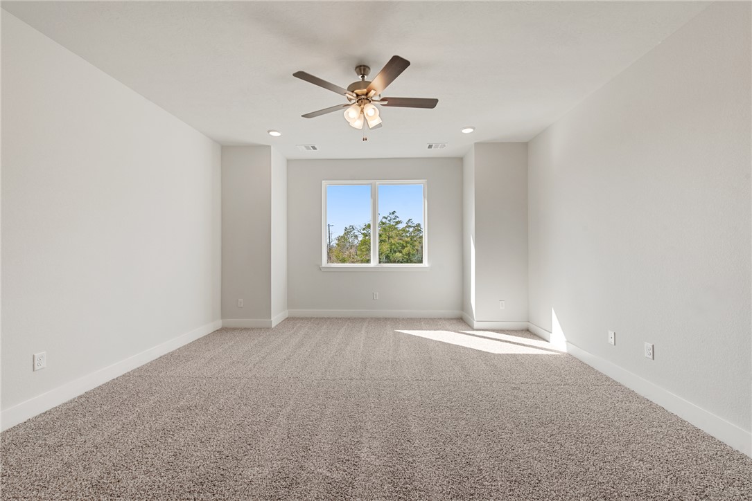 8452 Muir Wood Loop Anderson, TX 77830 - Photo 35 of 48 an empty room with windows and ceiling fan
