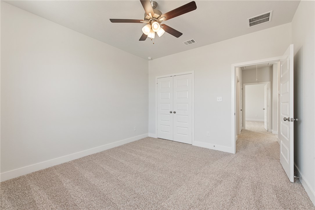 8452 Muir Wood Loop Anderson, TX 77830 - Photo 37 of 48 an empty room with closet and a chandelier fan