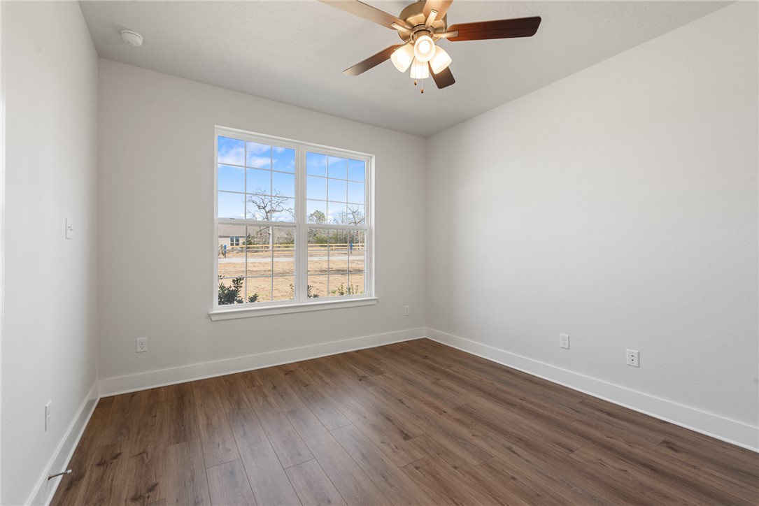 8452 Muir Wood Loop Anderson, TX 77830 - Photo 4 of 48 wooden floor in an empty room with a window